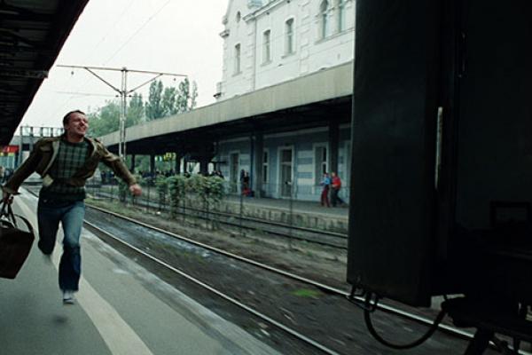 Man running to a platform to catch a leaving train