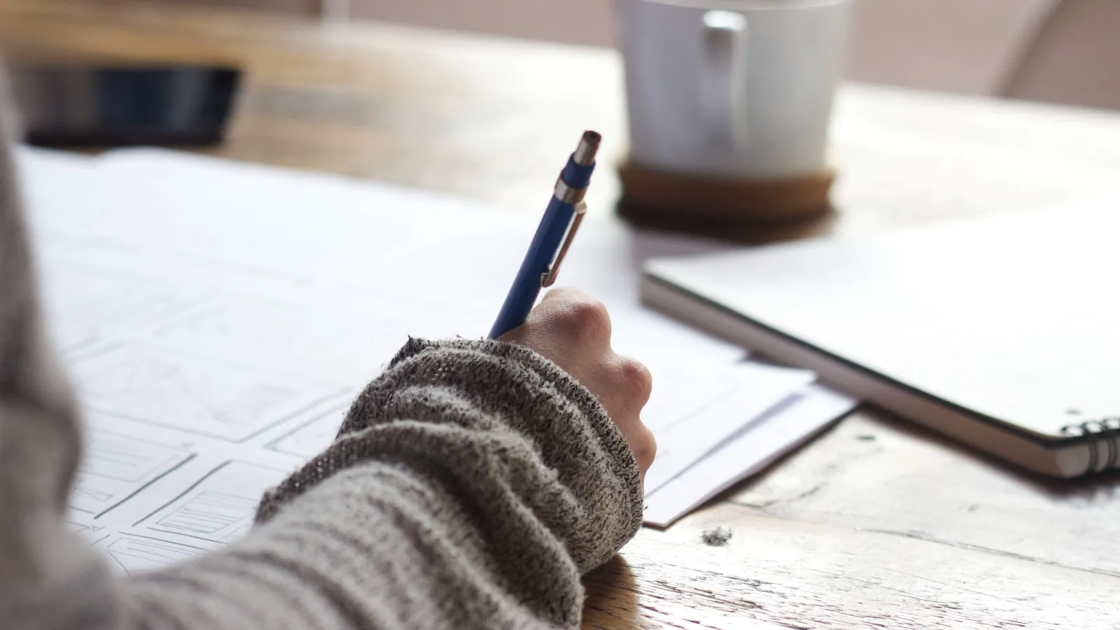 Student with a pencil writing at a desk