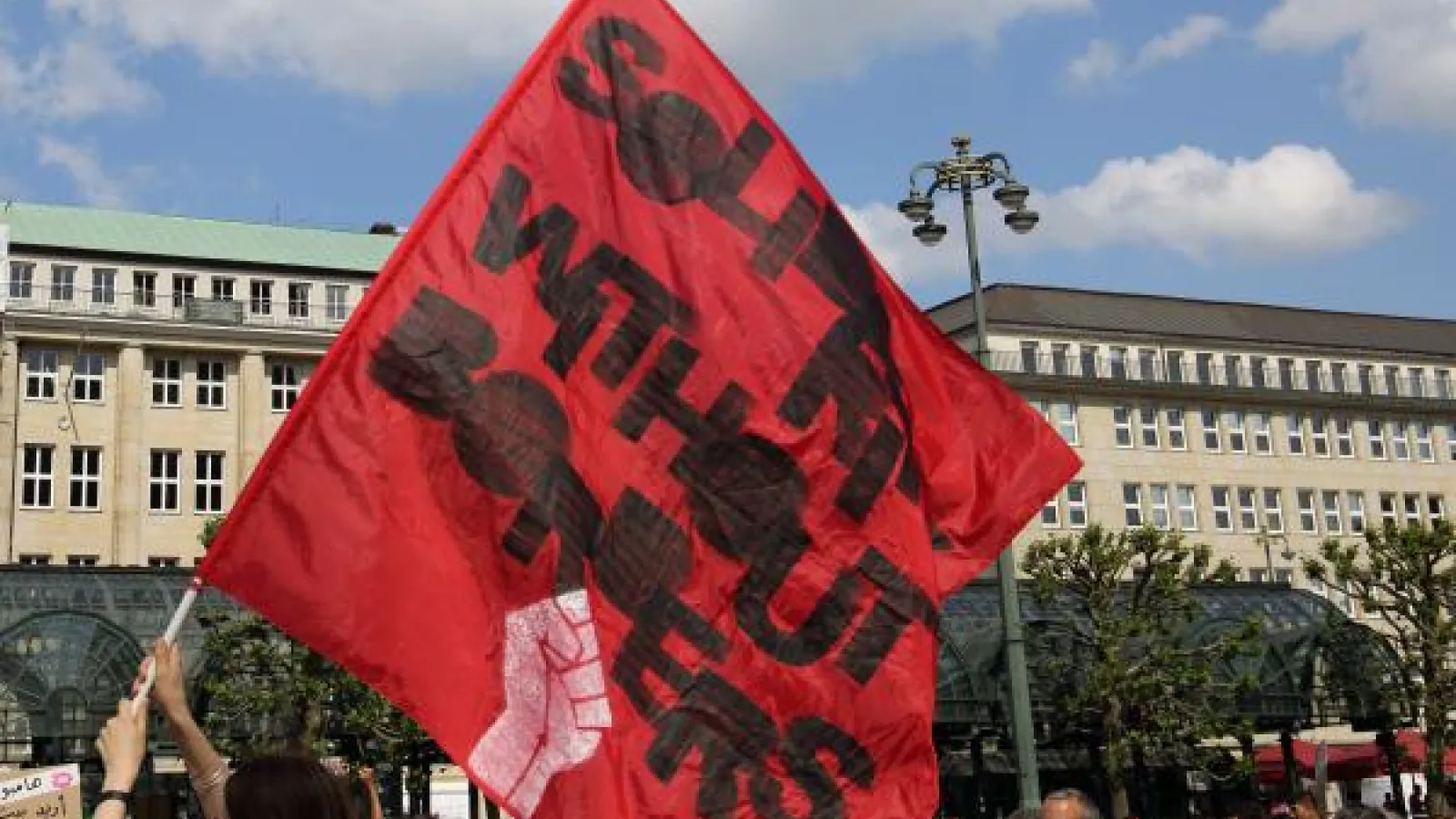 Waving a flag that says "Solidarity without borders"