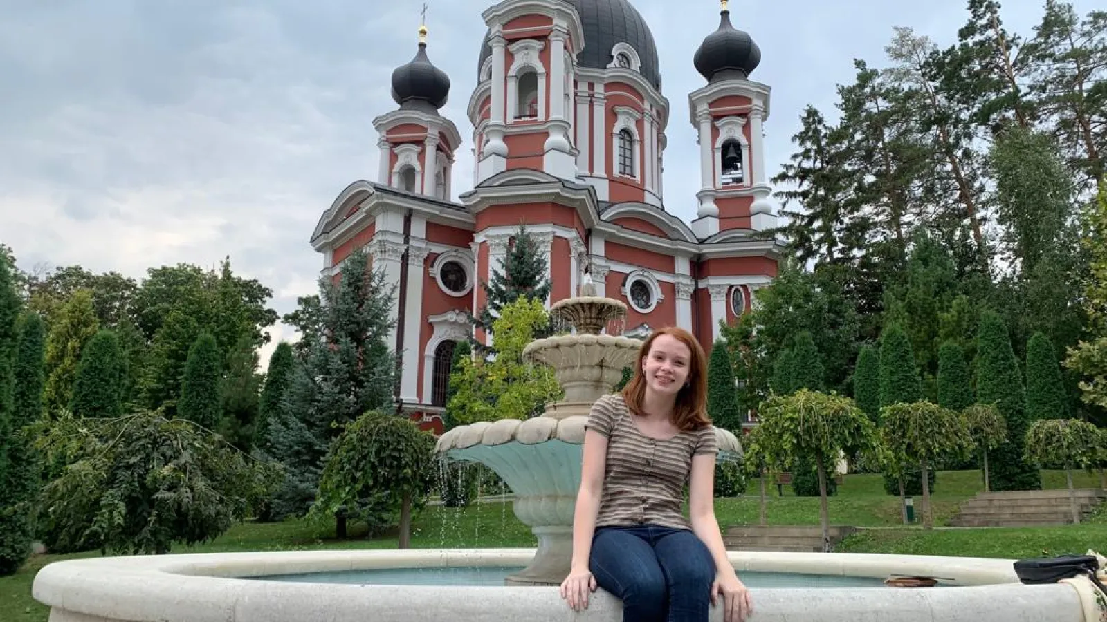 Sarah Holman sitting in front of a fountain