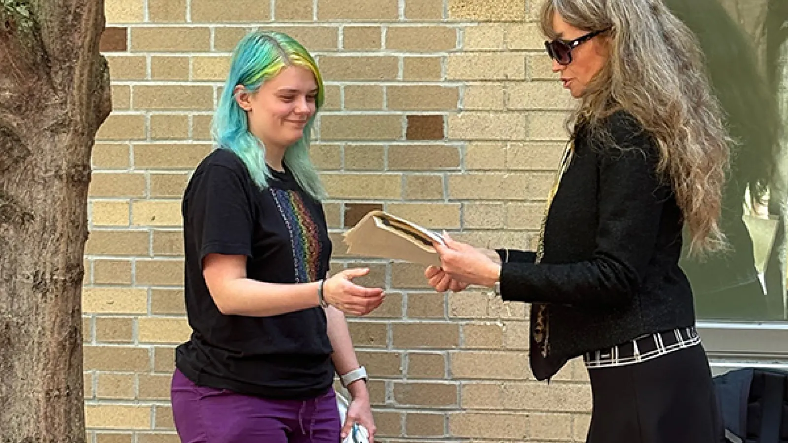A student receives an award from DSEELC Language Coordinator Larysa Stepanova at the Slavic Spring Tea 2024