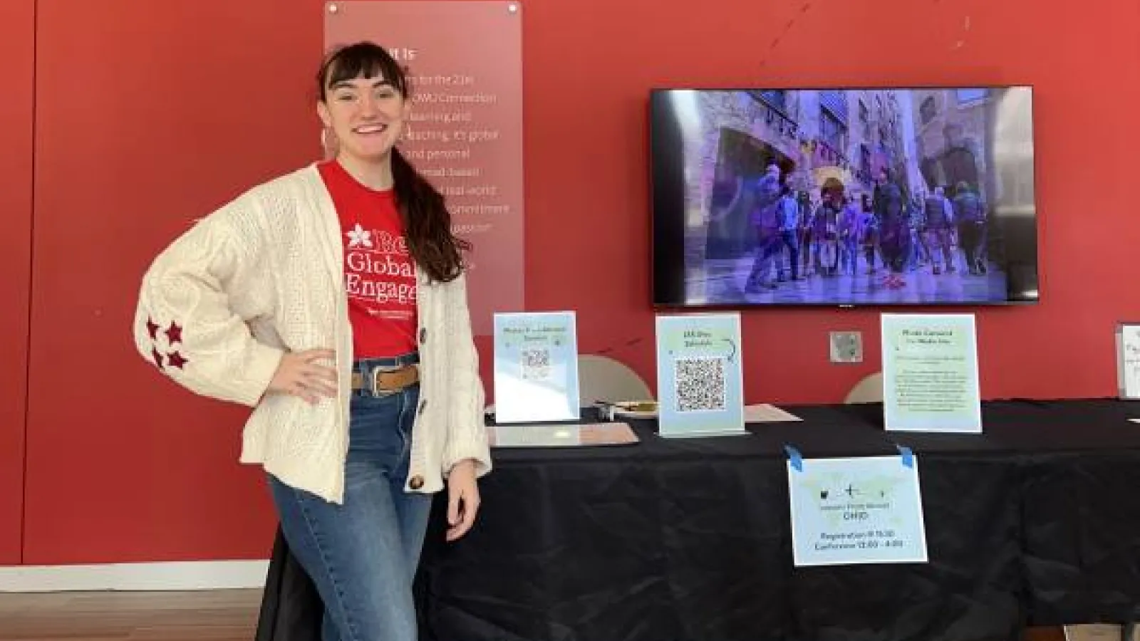 Alexis Voisard poses in front of the conference registration table at the Lessons from Abroad Conference
