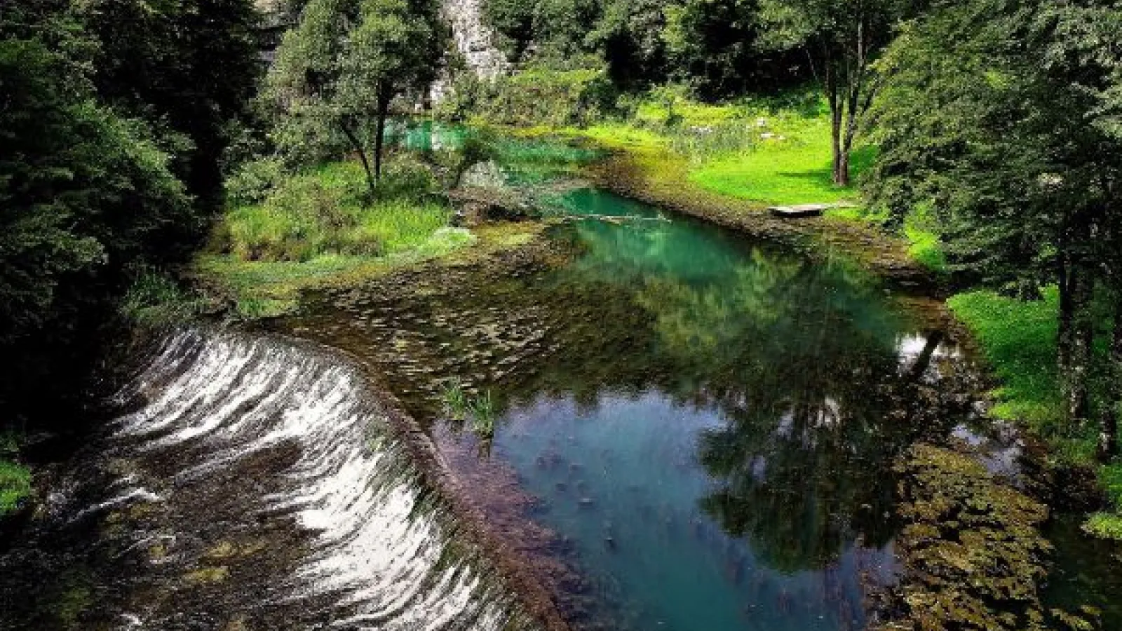 A karst spring in Slovenia in a verdant mountain landscape