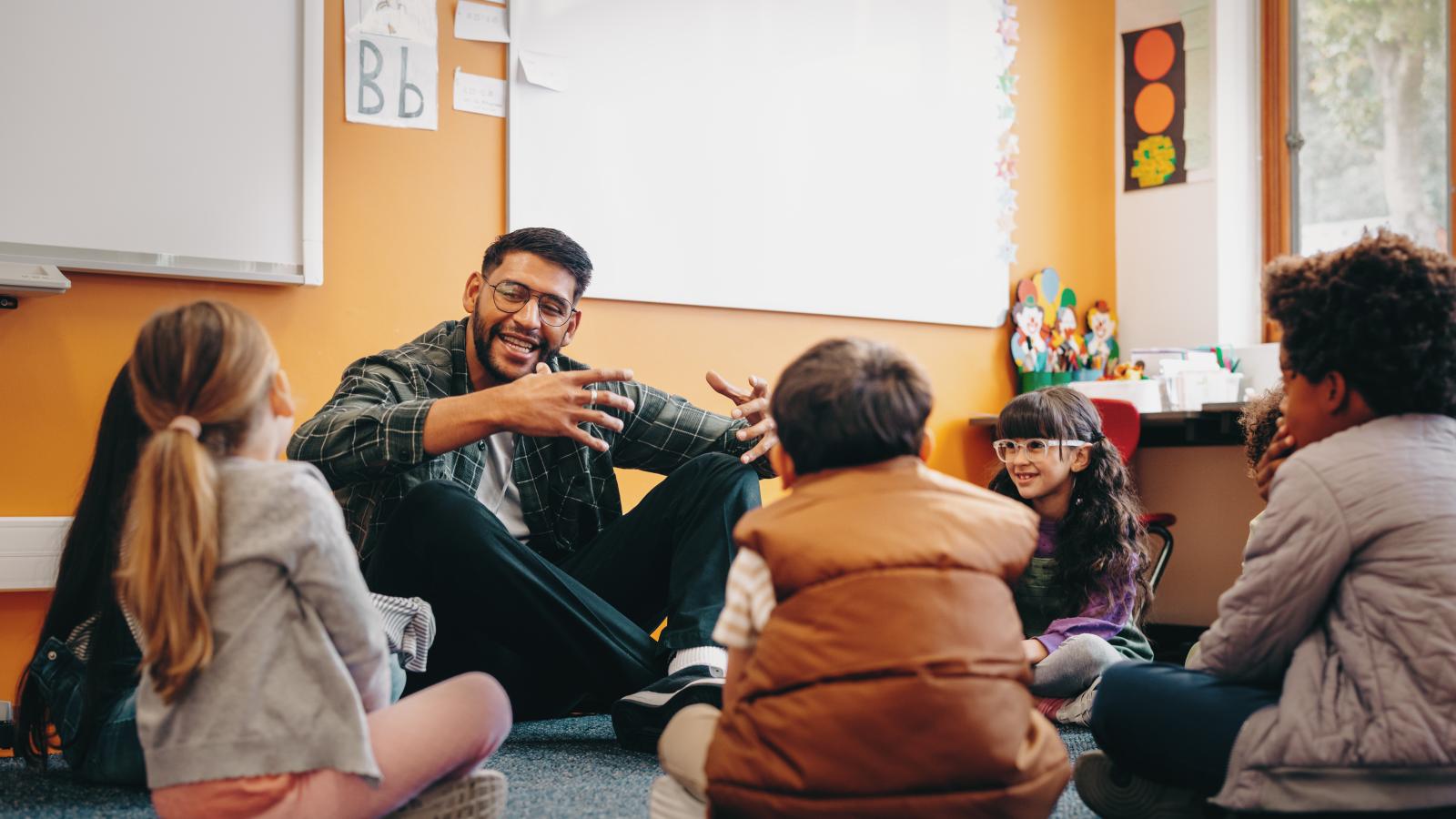 Guest speaker sitting down and with K-12 students and talking to them