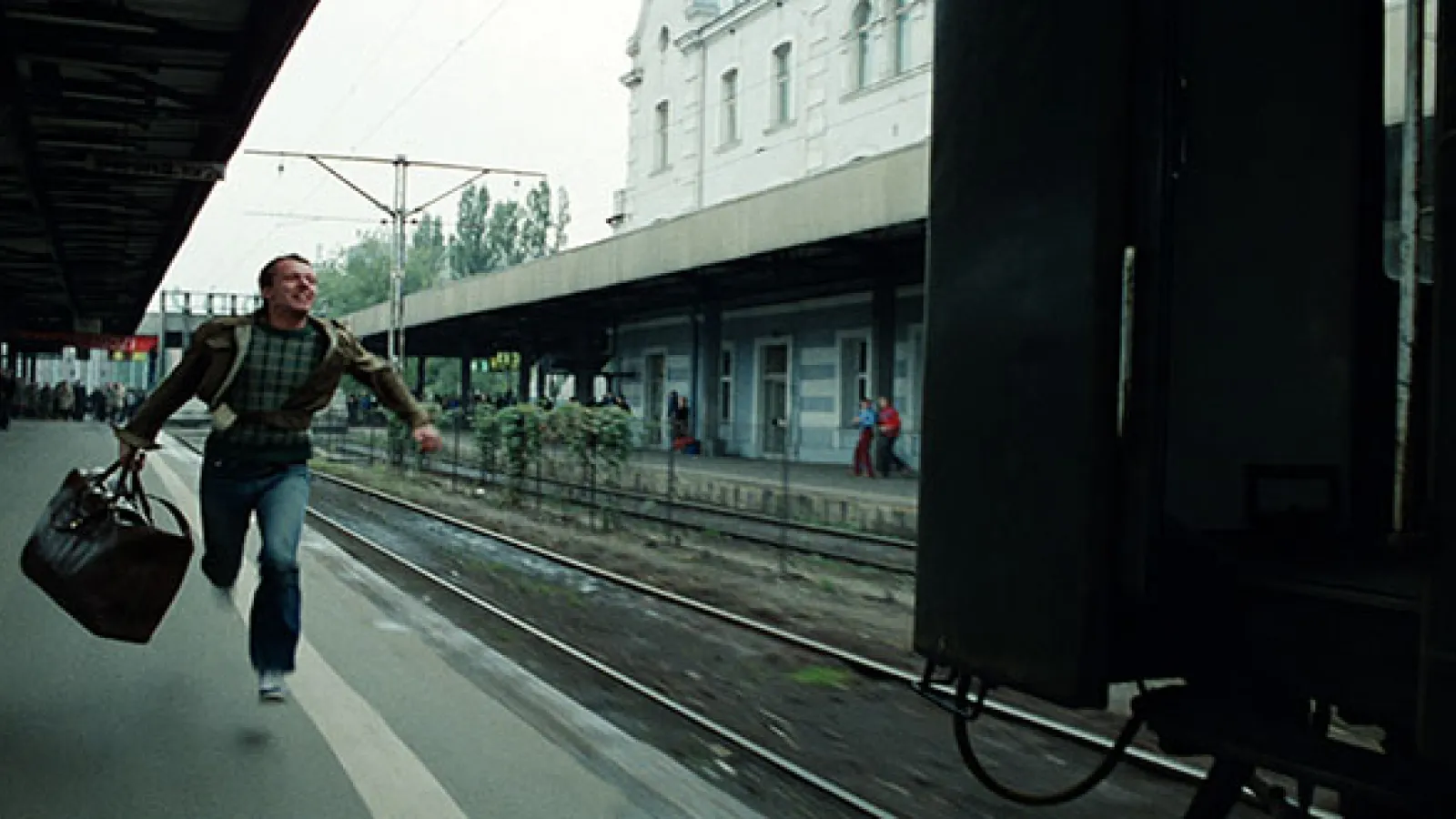Man running to a platform to catch a leaving train