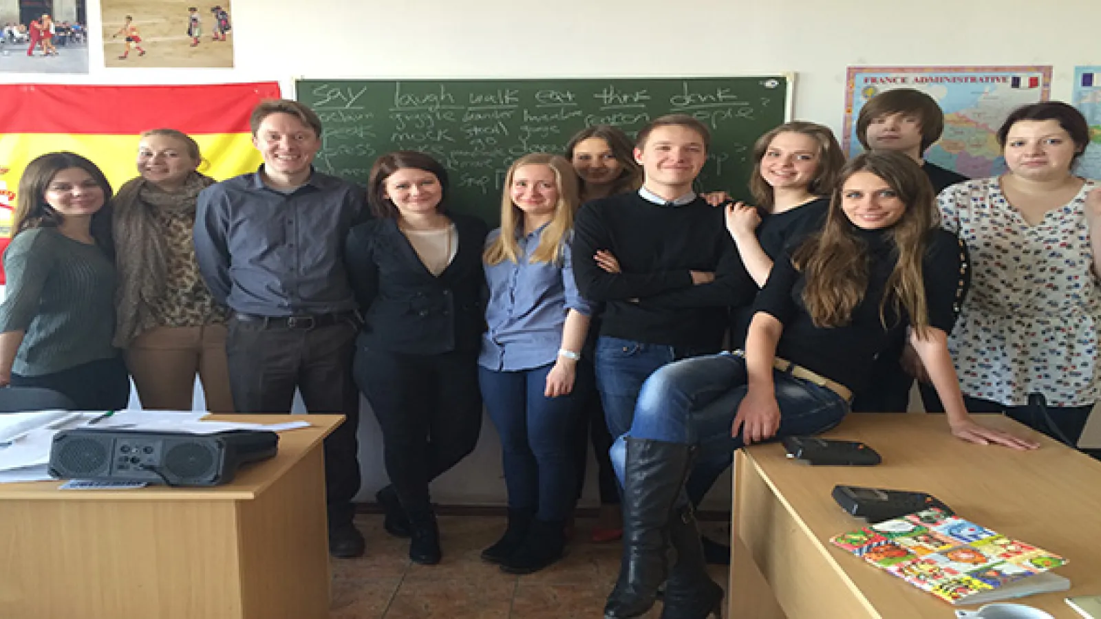 Large group of students standing in front of classroom