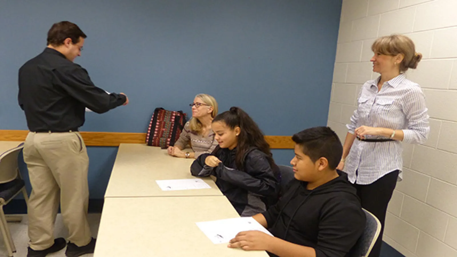 Five high school students stand in a row with their teacher and staff from Ohio State