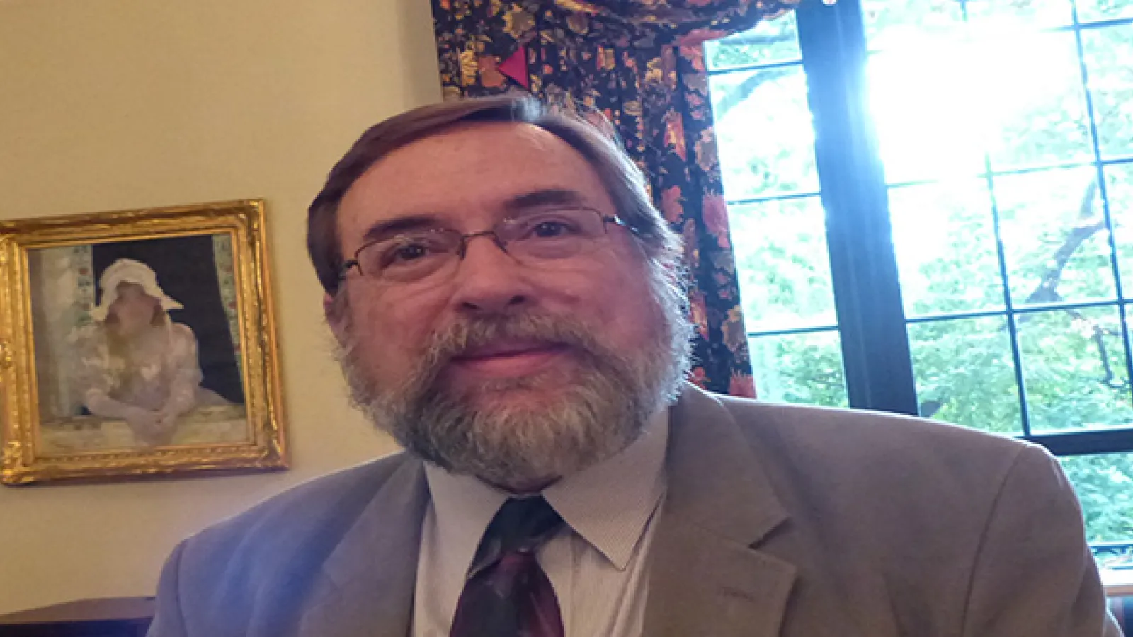 Photo of man's face up from neck up with glasses and smiling