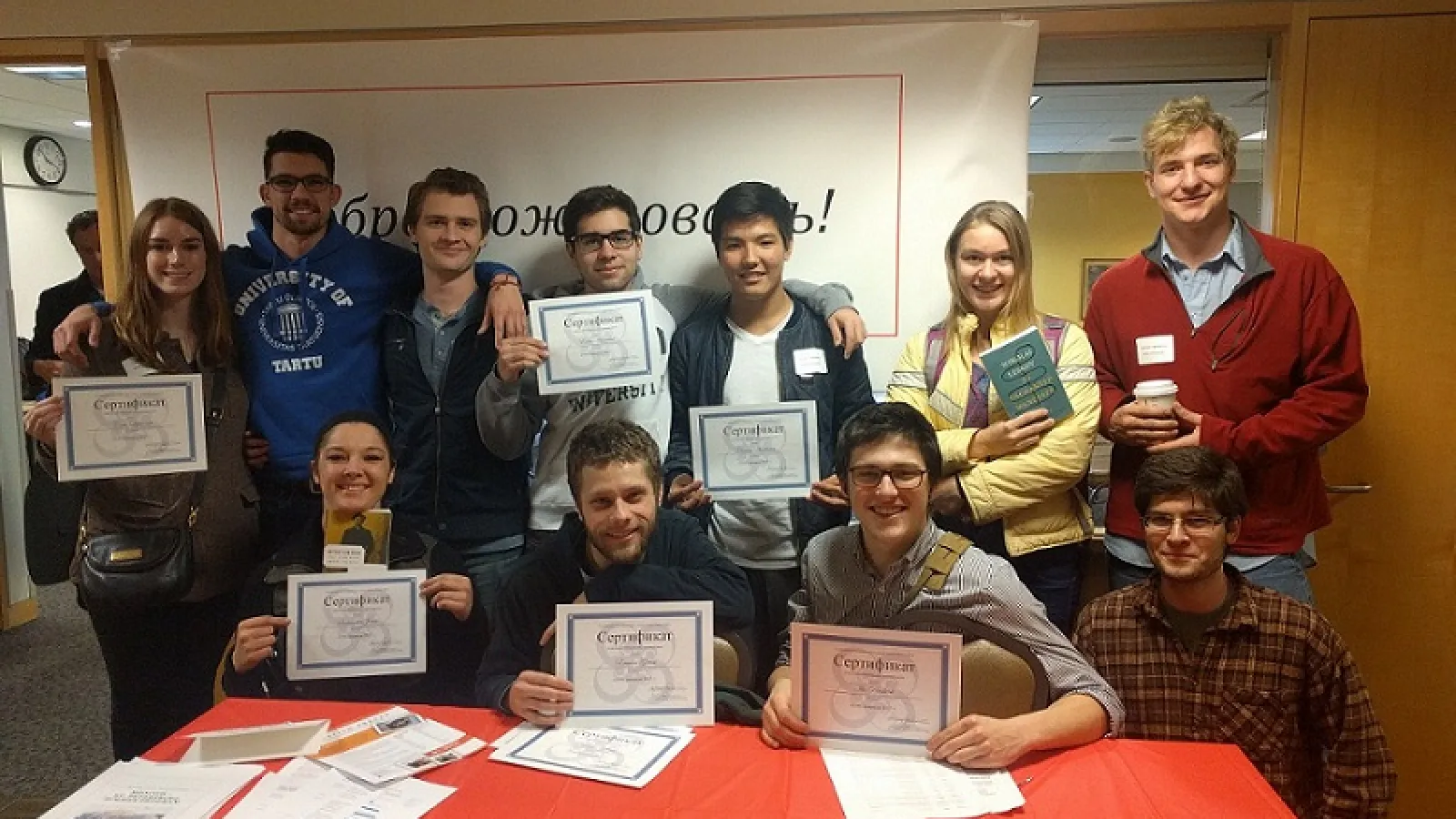 Two rows of students holding up certificates
