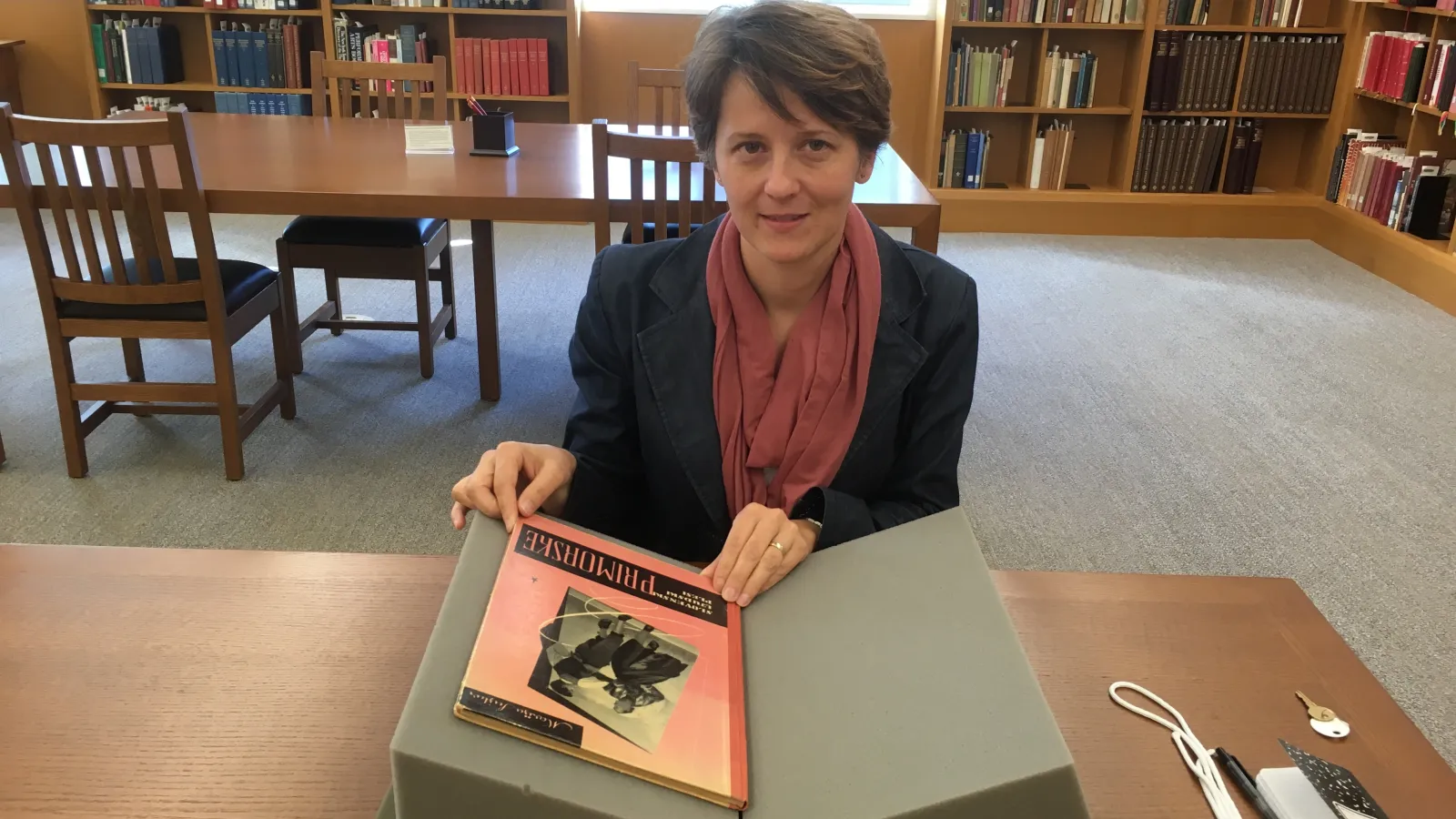 Woman sitting at a desk with book open in front of her
