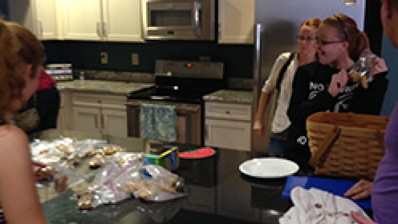 Students standing around a kitchen island