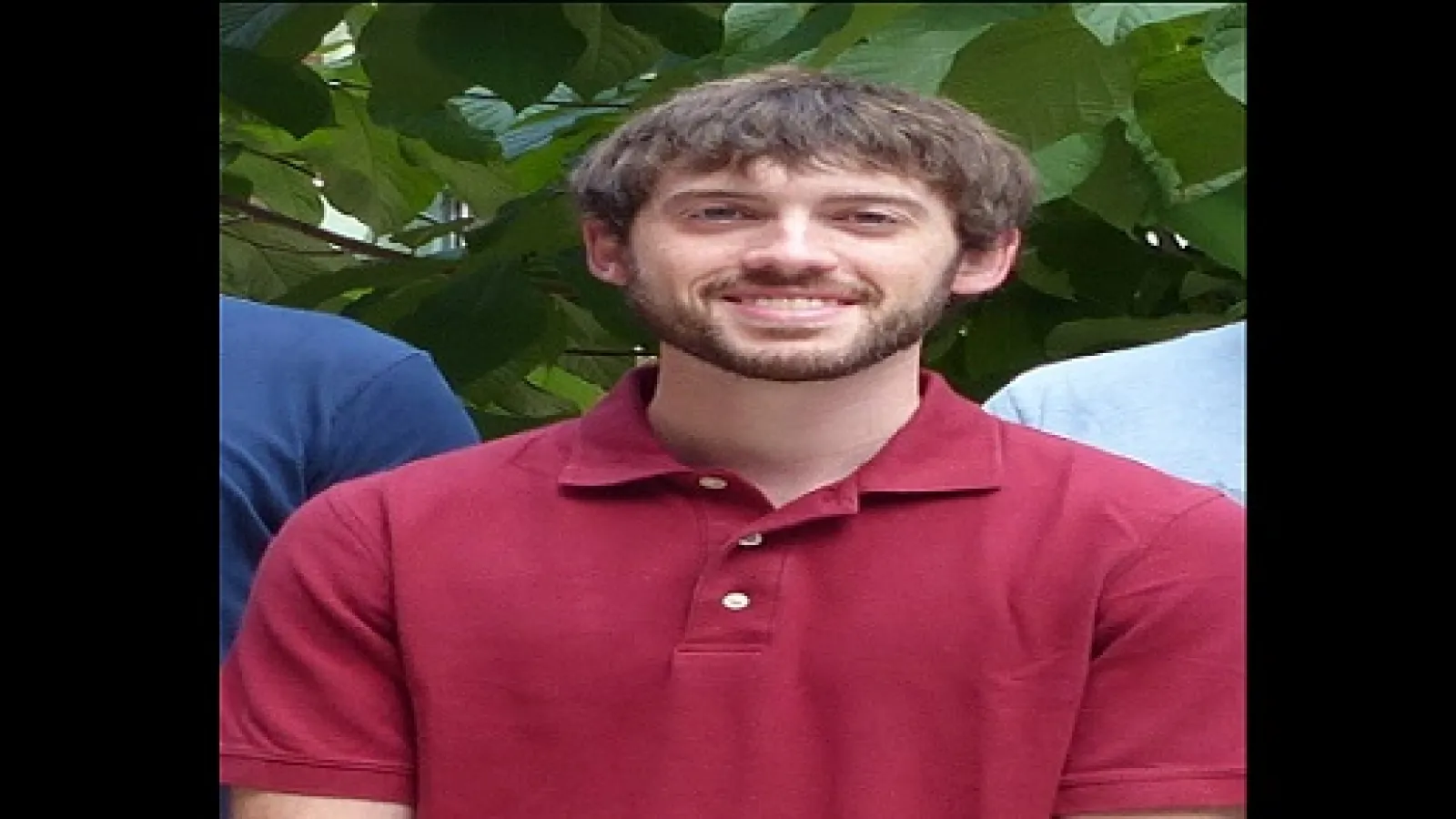 Man wearing a red shirt looking at the camera