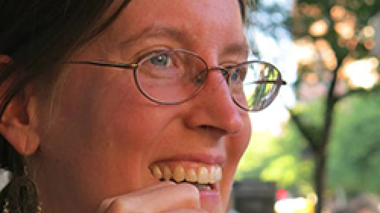 Close up of woman's face looking at the camera who is wearing glasses