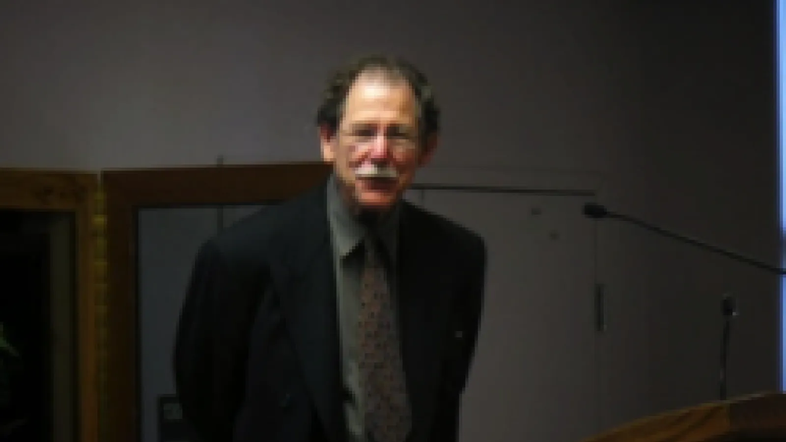 John Friedman standing in a dark room 
