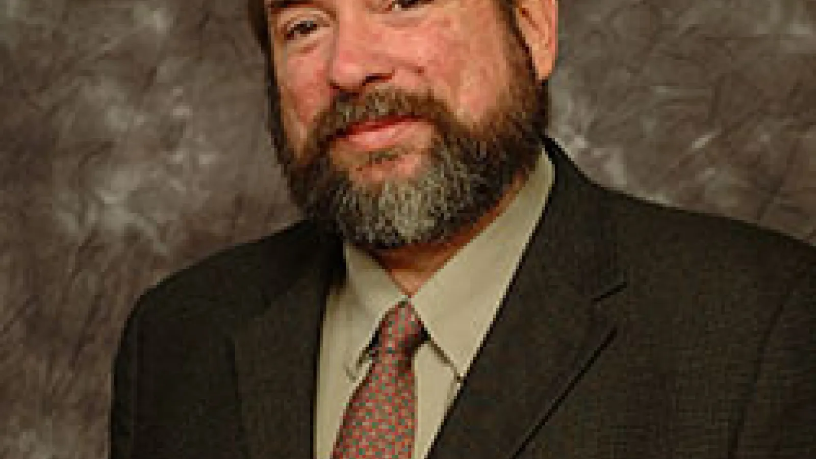 Closeup photo of man, torso up in a suit