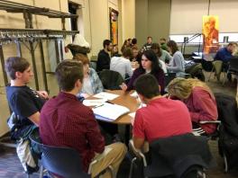 Kamola Azimova Discussing Uzbekistan Students sitting around a round table listening to a woman speak