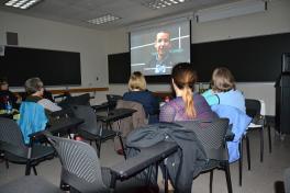 People sitting in chairs looking at a film screen
