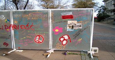 Silver upright panels covered in writing and paint