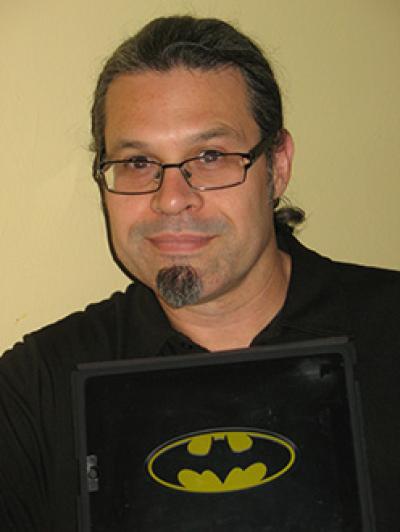 A man holding a Batman logo