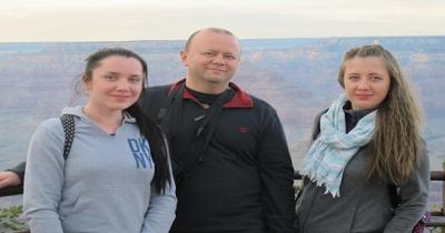 Two women and a man standing next to each other with the Grand Canyon in the background