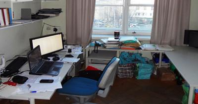 Desk and chair with bookshelves, window 