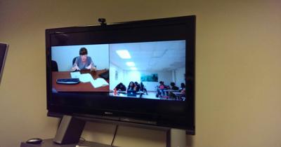 Dr. Mila Nazyrova Speaking to Howard University Students Woman with glasses sitting at desk speaking