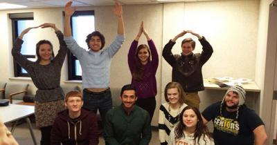 OSU Undergraduate Olympiada Participants Four students standing in back row making O-H-I-O, five kneeling in front