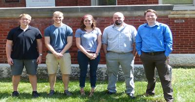 New CSEES MA Students 2015-16 Four men and a woman standing next to each other facing the camera in front of a red brick building