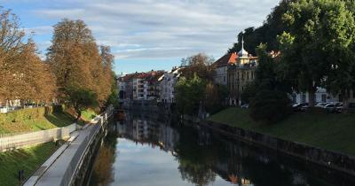 Ljubljanica River, Ljubljana, Slovenia. Photo by M.A. Johnson Park and houses in the distance on the banks of a river