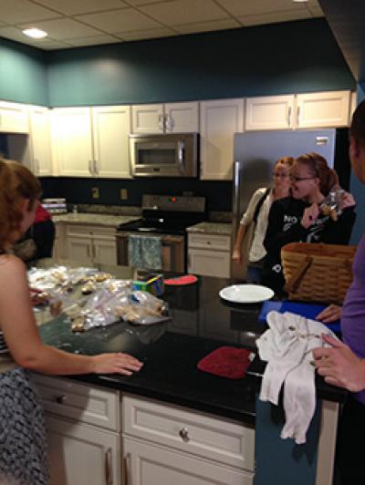 Students standing around a kitchen island