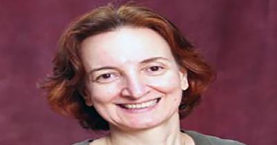 Former Director, Dr. Yana Hashamova Photo of woman's face from neck up with red background