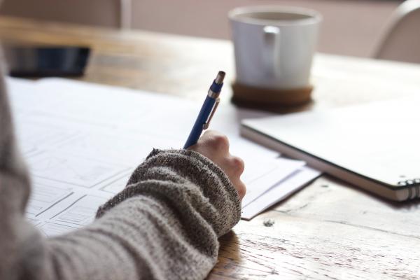 Student with a pencil writing at a desk