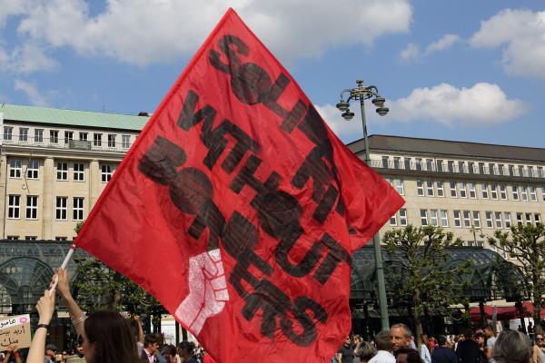 Waving a flag that says "Solidarity without borders"