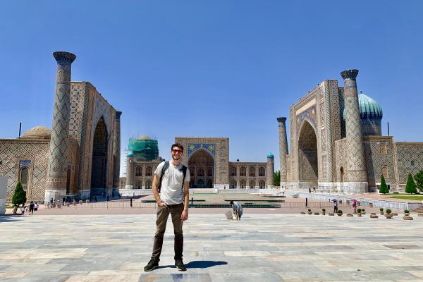 Kyle Erickson standing in front of the Registan, a collection of madrasahs built between the 15th and 17th centuries in Samarkand.