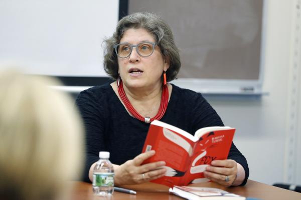 Ellen Elias-Bursać reading aloud from a book in front of an audience