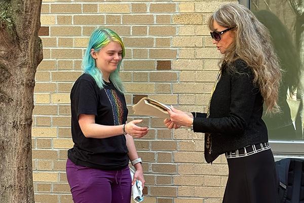 A student receives an award from DSEELC Language Coordinator Larysa Stepanova at the Slavic Spring Tea 2024