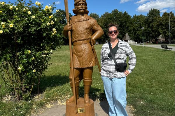 Lauren Hayden standing next to a wooden statue in Giecz, Poland