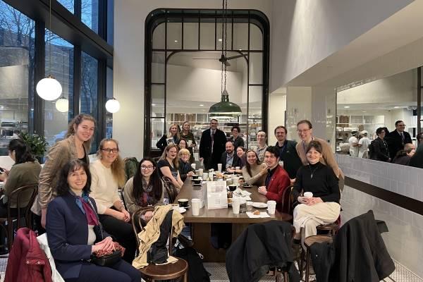 A group photo of CSEEES students, alumni, faculty and staff in a coffee shop