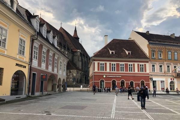The city of Sibiu, Romania, featuring an old square with a Starbucks coffee shop