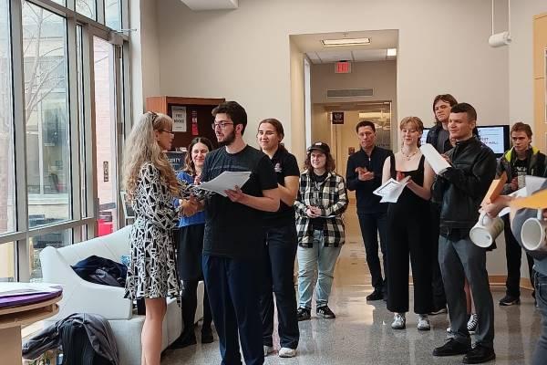 Dr. Larysa Stepanova presents FLAS Fellow William Slabodkin with a certificate as other students applaud