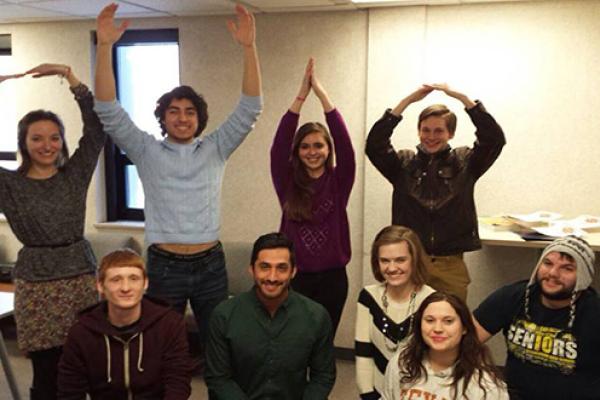 Four students standing in back row making O-H-I-O, five kneeling in front