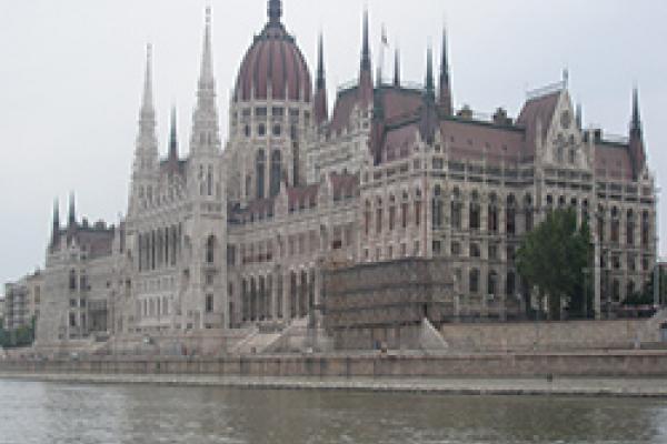 Parliament Building in Budapest Long Gothic building with red tile roof on the banks of a river