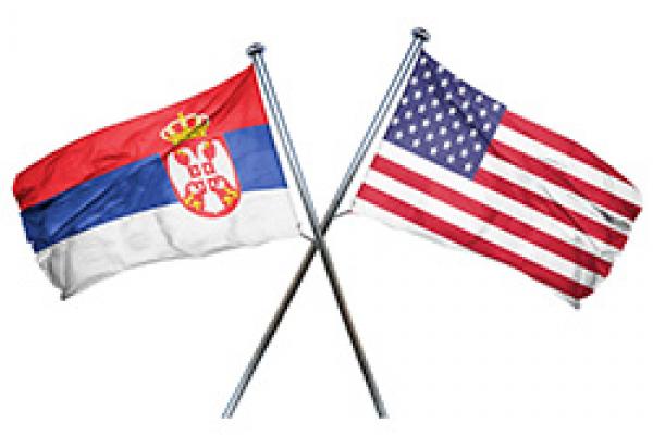 US flag hanging to the right, Serbian flag crossed over hanging to the left