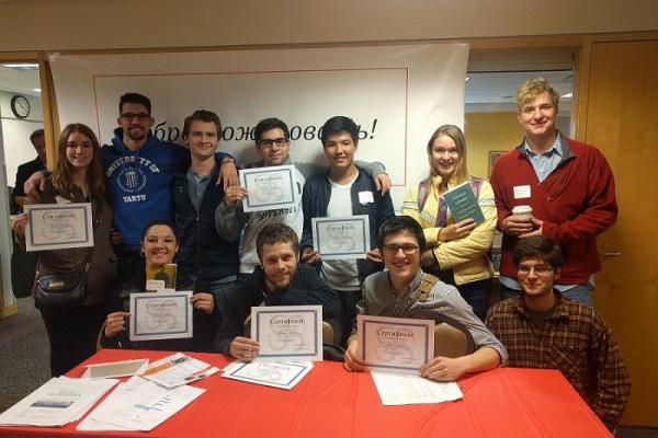Two rows of students holding up certificates