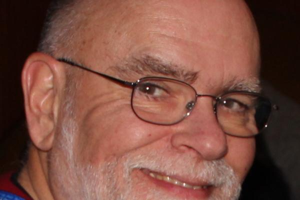 Close up photo of man's face with a beard and wearing glasses