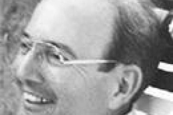 Close of man's face, smiling, wearing glasses