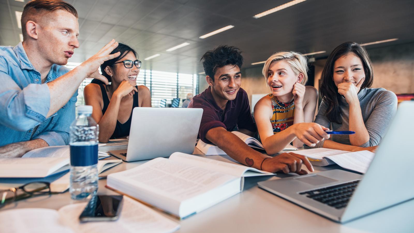 Group of students seated at a table working together on a project