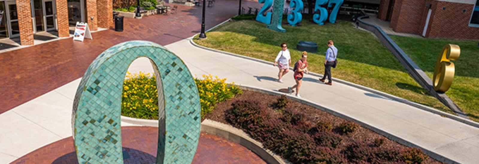 Photograph of The Garden of Constants Public Art with Enarson Classroom Building and parking garage in background.. Artist Barbara Grygutis