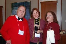 A man and two women standing should-to-should smiling